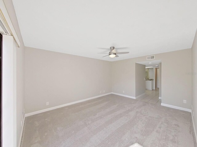 carpeted spare room featuring ceiling fan