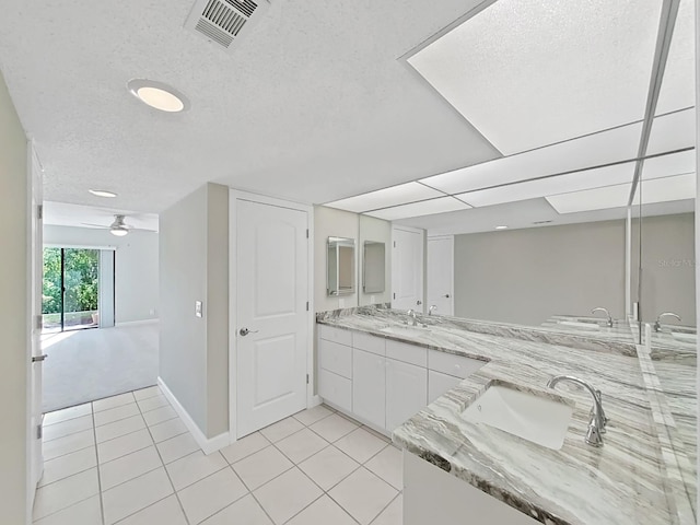 bathroom with ceiling fan, tile patterned flooring, vanity, and a textured ceiling