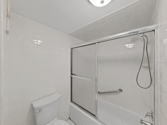 bathroom featuring toilet and enclosed tub / shower combo