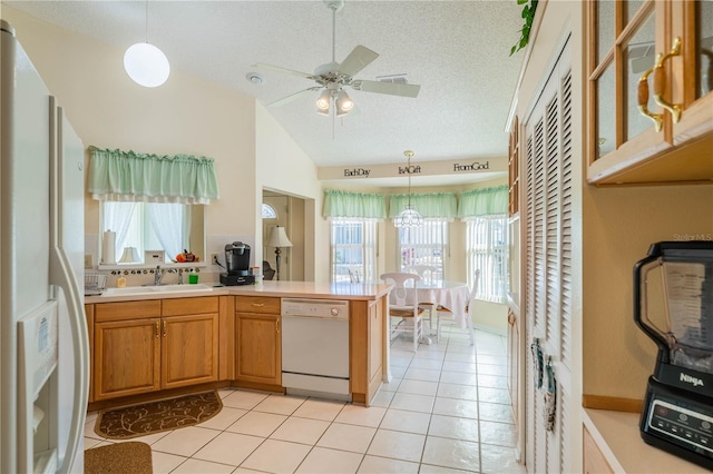 kitchen featuring ceiling fan with notable chandelier, white appliances, a textured ceiling, pendant lighting, and lofted ceiling