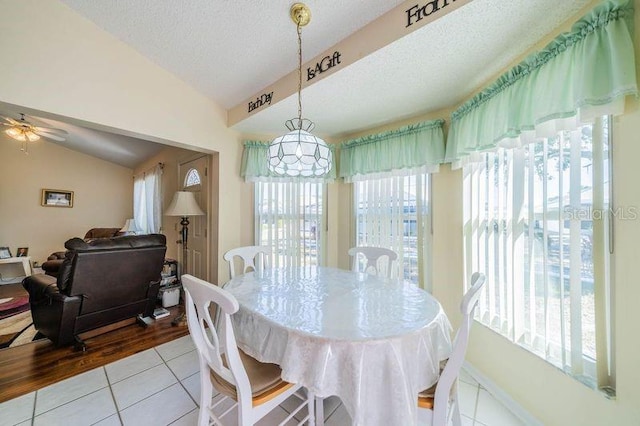 dining area with light tile patterned floors, lofted ceiling, and a wealth of natural light