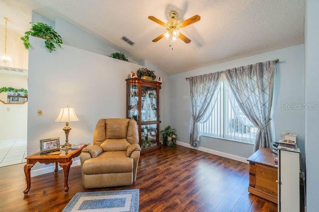 sitting room with a textured ceiling, ceiling fan, dark wood-type flooring, and vaulted ceiling