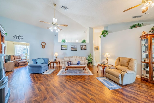 living room featuring a textured ceiling, ceiling fan, dark wood-type flooring, and high vaulted ceiling