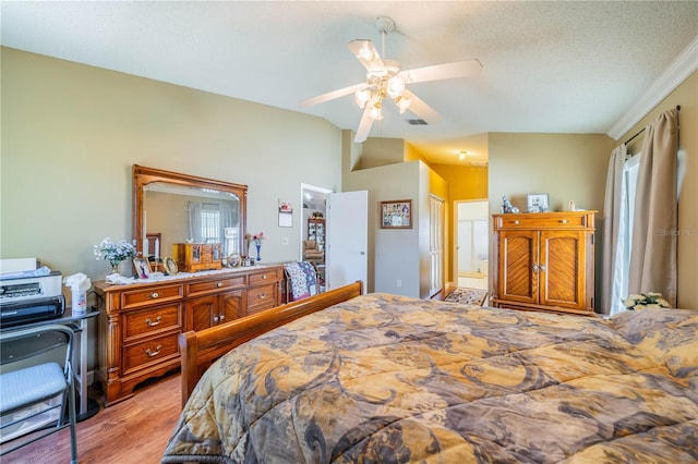 bedroom featuring ceiling fan, crown molding, a textured ceiling, lofted ceiling, and light wood-type flooring