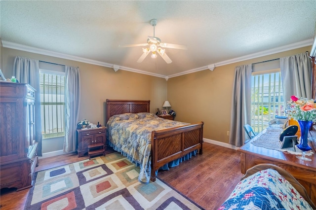 bedroom featuring ceiling fan, ornamental molding, a textured ceiling, and light wood-type flooring