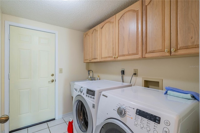 laundry room featuring cabinets, a textured ceiling, sink, washing machine and dryer, and light tile patterned flooring