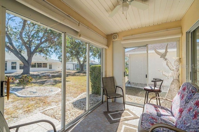 sunroom with ceiling fan and wooden ceiling