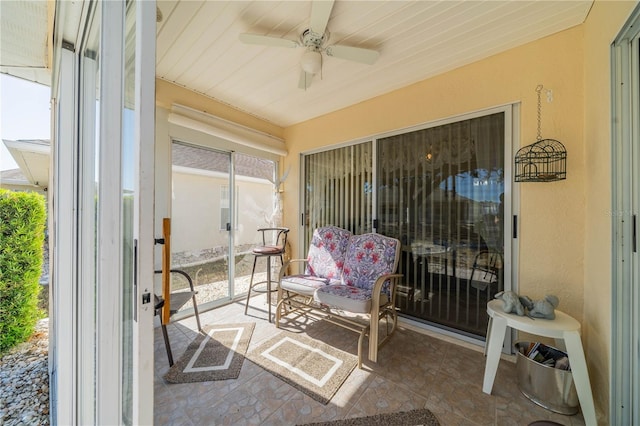 sunroom with ceiling fan and wood ceiling