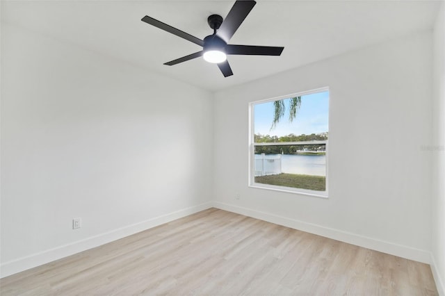 spare room featuring ceiling fan, a water view, and light hardwood / wood-style flooring