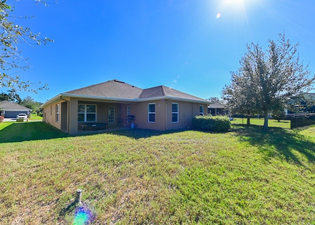 rear view of property featuring a lawn