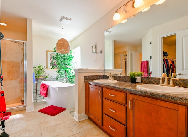 bathroom featuring tile patterned flooring, vanity, and plus walk in shower