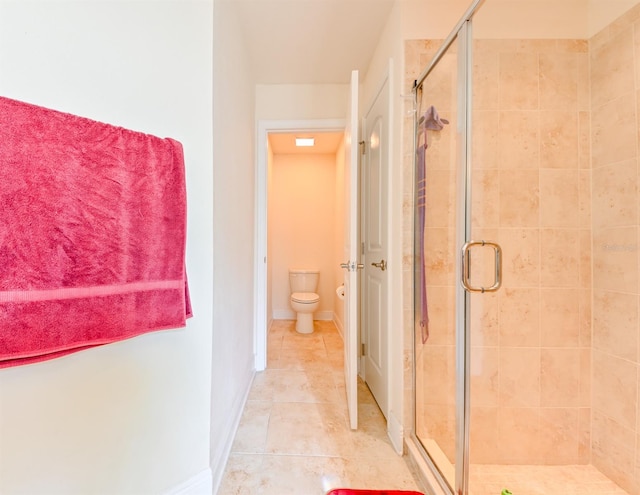 bathroom with tile patterned floors, toilet, and a shower with shower door