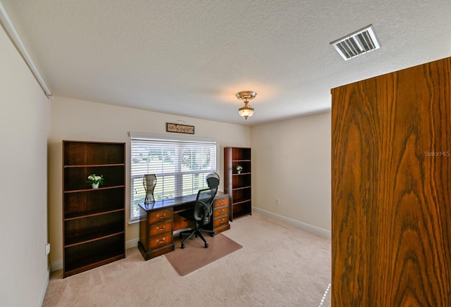 carpeted office with a textured ceiling