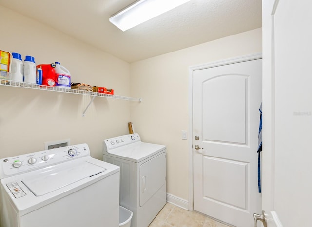 washroom with light tile patterned flooring, a textured ceiling, and washing machine and clothes dryer