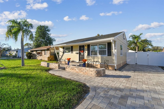 ranch-style house with a front yard and a patio area