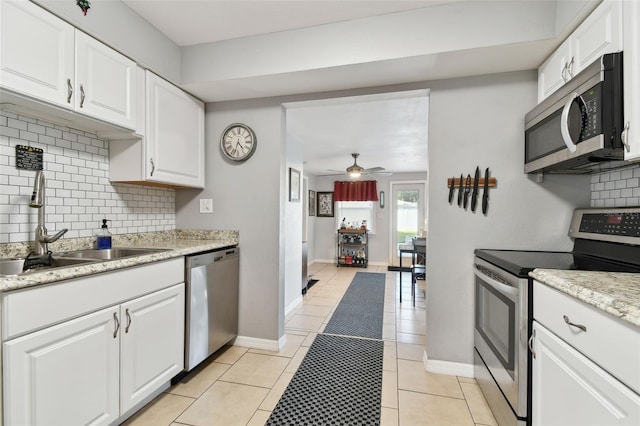 kitchen featuring white cabinets, ceiling fan, light tile patterned floors, tasteful backsplash, and stainless steel appliances