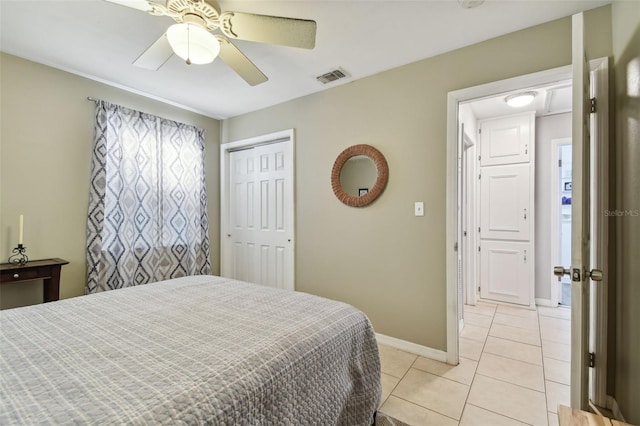 bedroom featuring ceiling fan, a closet, and light tile patterned floors