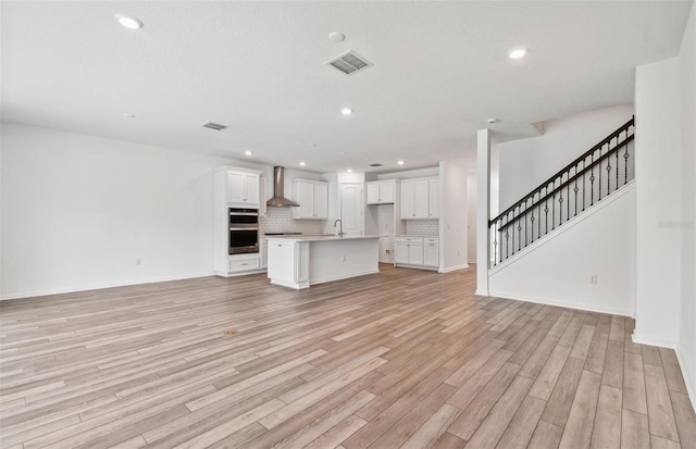 unfurnished living room with light hardwood / wood-style flooring and sink