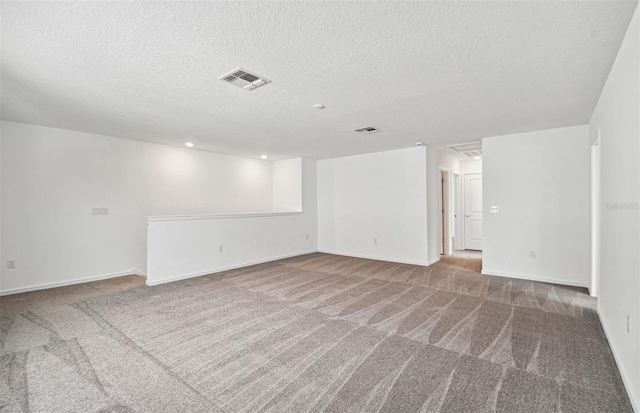 spare room featuring carpet flooring and a textured ceiling