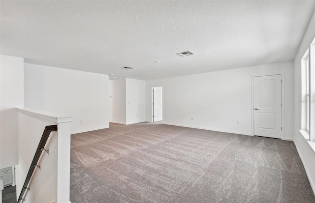 carpeted empty room with a textured ceiling