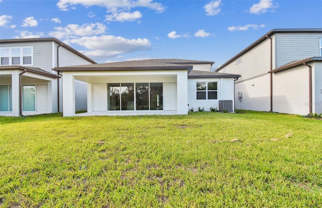 rear view of property with a yard and central AC unit