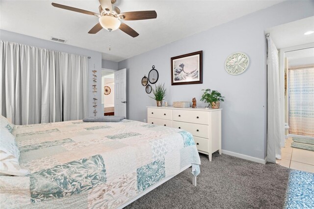 bedroom featuring connected bathroom, light colored carpet, and ceiling fan