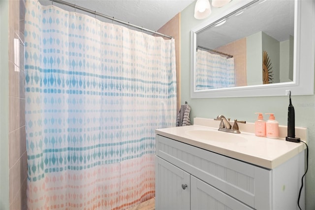 bathroom with vanity, a textured ceiling, and walk in shower