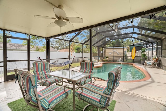 view of pool featuring ceiling fan, a lanai, a shed, and a patio