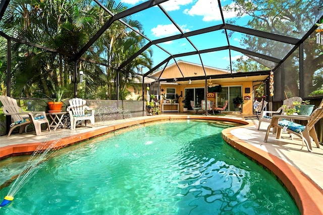 view of swimming pool with a lanai, ceiling fan, pool water feature, and a patio