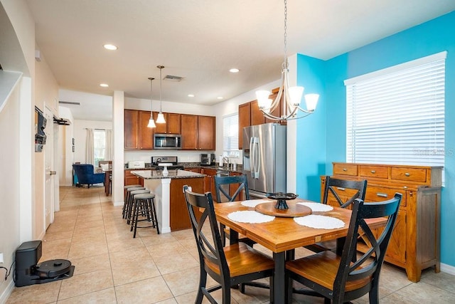 dining area featuring sink, plenty of natural light, light tile patterned flooring, and an inviting chandelier