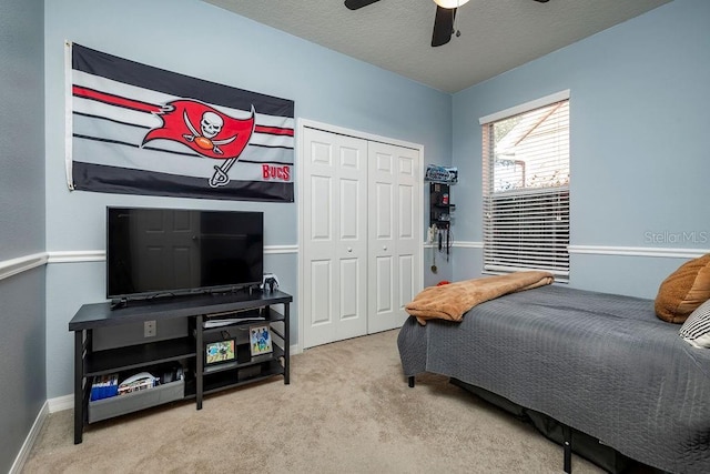 carpeted bedroom featuring a textured ceiling, a closet, and ceiling fan