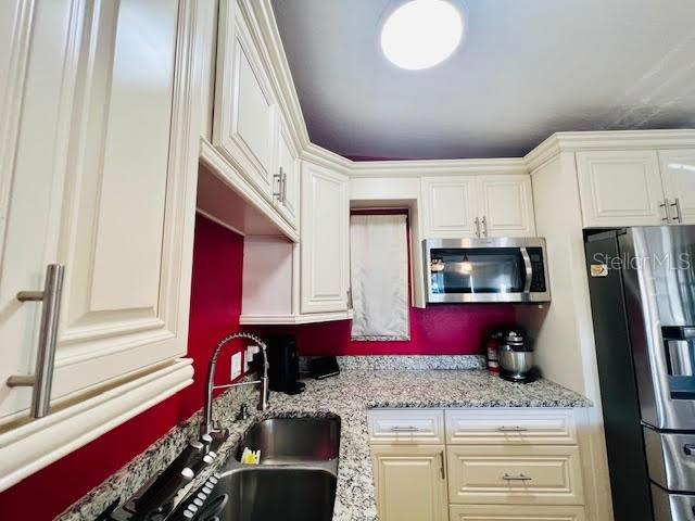 kitchen with light stone countertops and stainless steel appliances