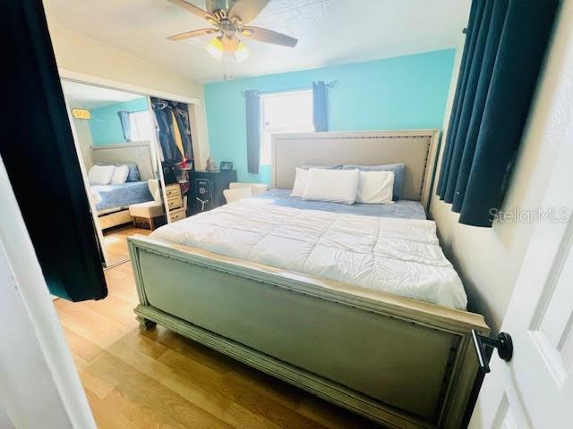 bedroom featuring ceiling fan, a closet, and light hardwood / wood-style flooring