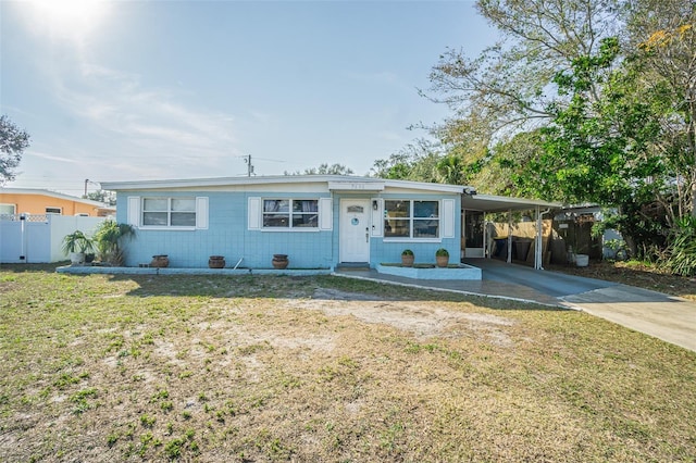 ranch-style house featuring a carport and a front lawn