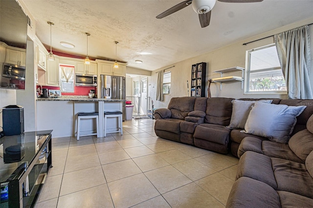 9696 Groveland St, Seminole, FL 33772 - living room with light tile patterned flooring, ceiling fan, and a textured ceiling
