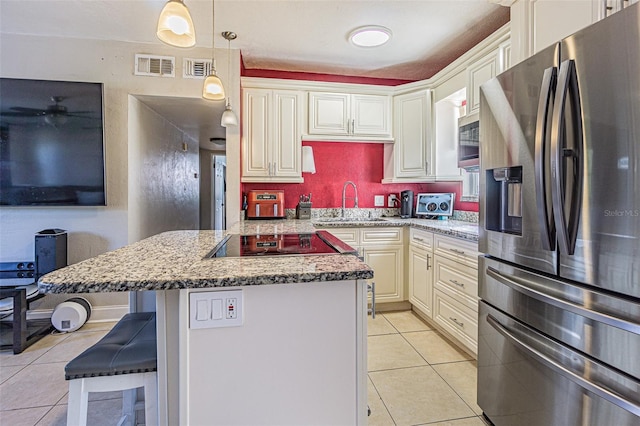 9696 Groveland St, Seminole, FL 33772 - kitchen featuring light tile patterned floors, a kitchen bar, stainless steel appliances, light stone counters, and a kitchen island