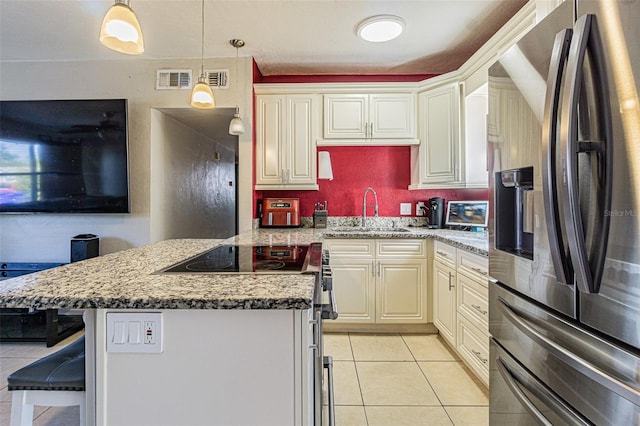 9696 Groveland St, Seminole, FL 33772 - kitchen featuring light tile patterned floors, appliances with stainless steel finishes, a kitchen island, pendant lighting, and light stone countertops