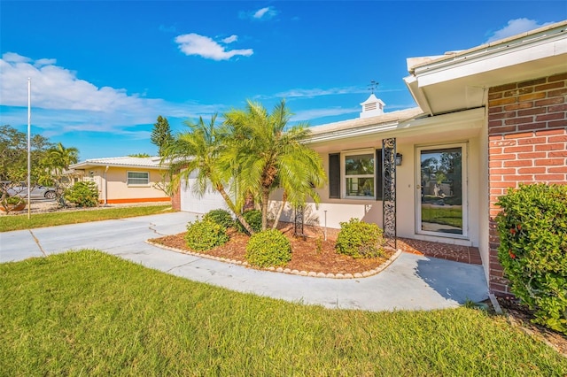 entrance to property featuring a yard and a garage