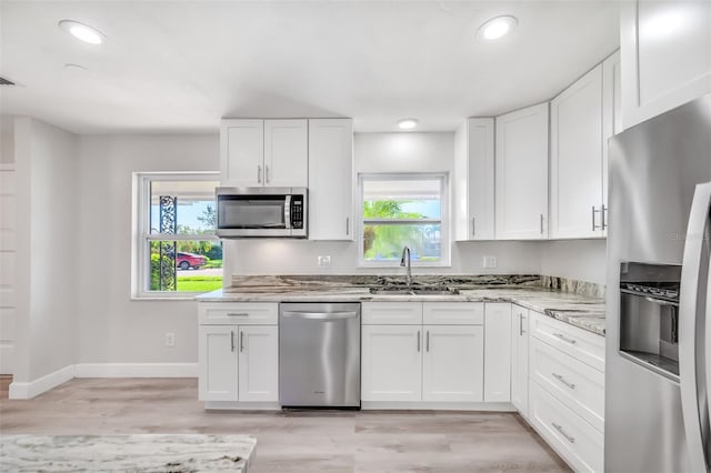 kitchen featuring white cabinets, appliances with stainless steel finishes, and a healthy amount of sunlight