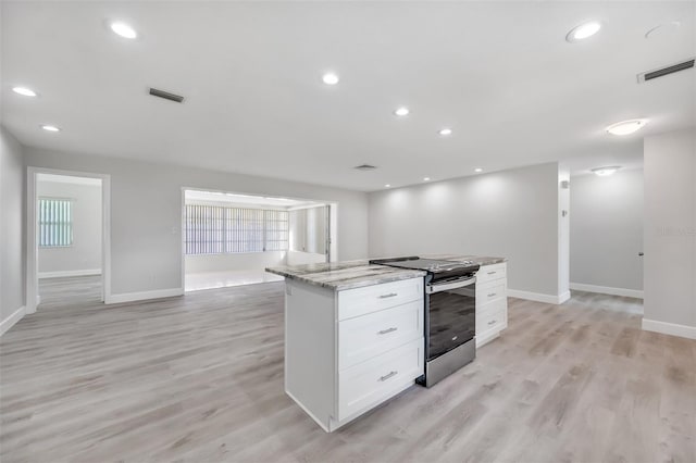 kitchen featuring white cabinetry, a center island, light stone counters, stainless steel range with electric stovetop, and light wood-type flooring