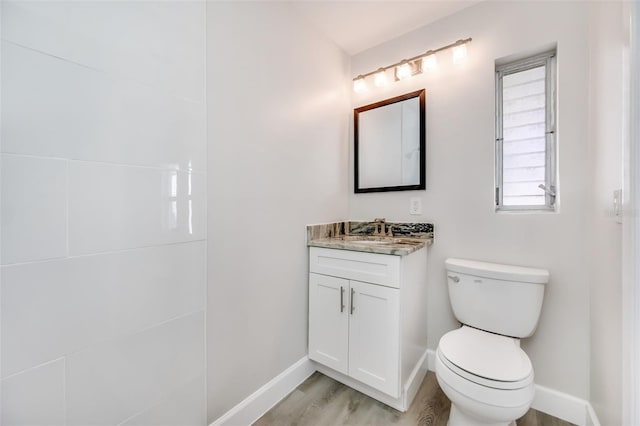 bathroom with toilet, vanity, and hardwood / wood-style flooring