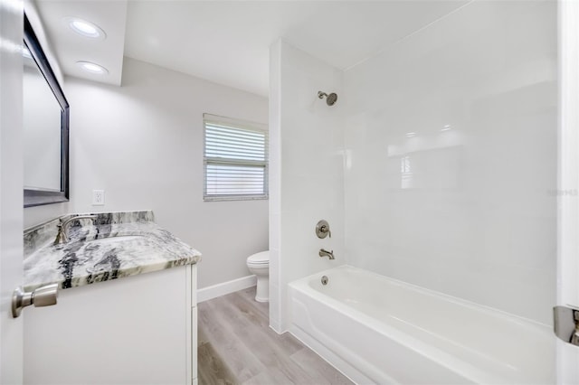 full bathroom with vanity, tiled shower / bath, wood-type flooring, and toilet