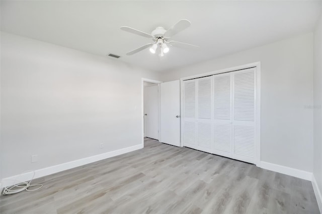 unfurnished bedroom featuring a closet, light hardwood / wood-style flooring, and ceiling fan