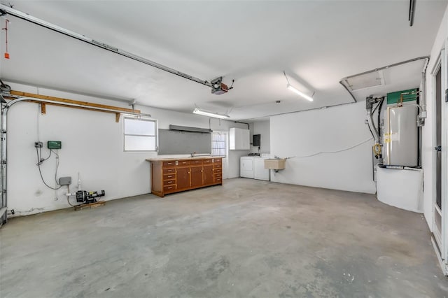 garage featuring a garage door opener, washer and clothes dryer, and sink