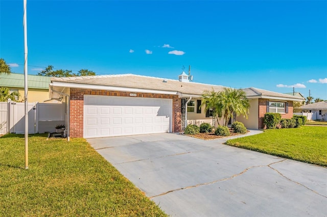 single story home with a garage, a front yard, brick siding, and driveway