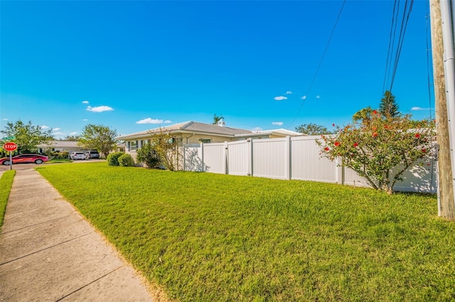 view of side of home featuring a yard and fence