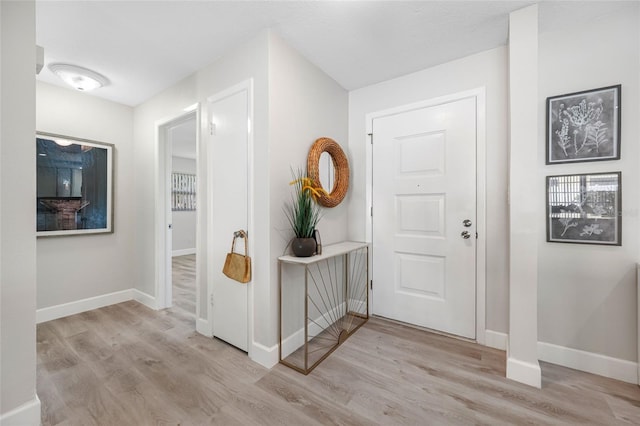 entrance foyer featuring light wood finished floors and baseboards