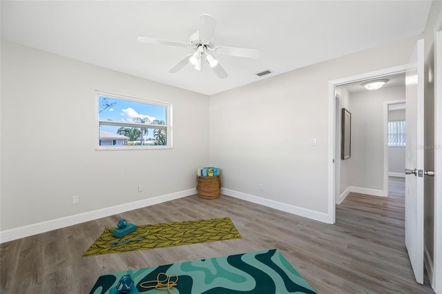 exercise area with plenty of natural light, wood finished floors, and visible vents