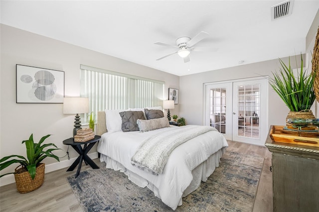 bedroom with baseboards, visible vents, wood finished floors, access to exterior, and french doors