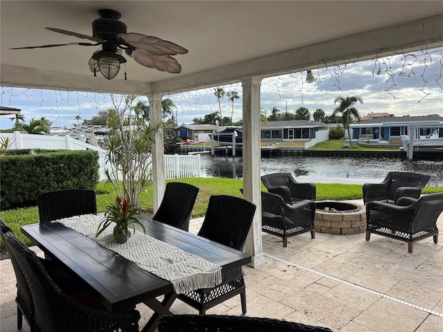 view of patio / terrace with ceiling fan, a water view, and a fire pit